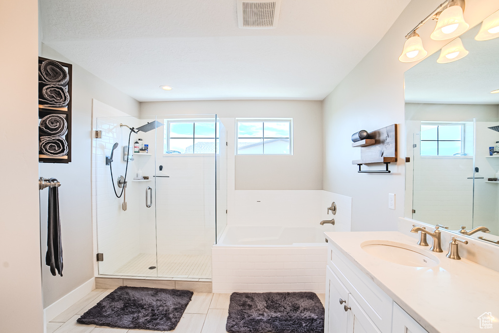 Full bathroom with healthy amount of natural light, a garden tub, and a shower stall