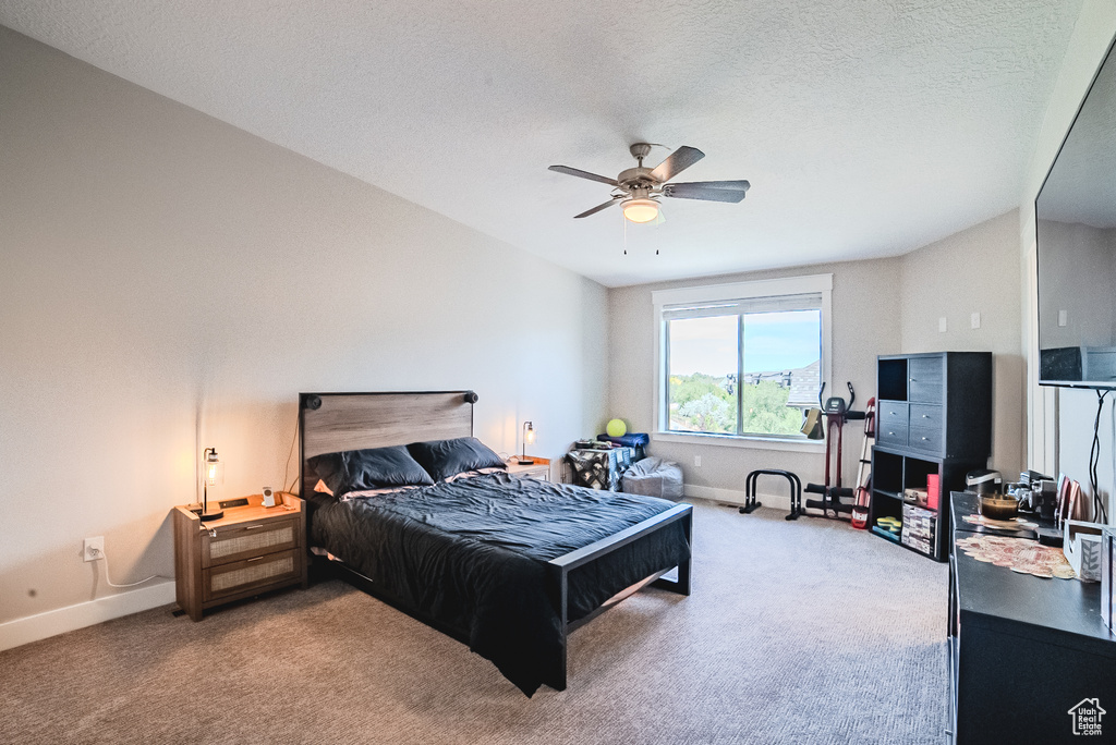 Bedroom with carpet, a textured ceiling, and ceiling fan