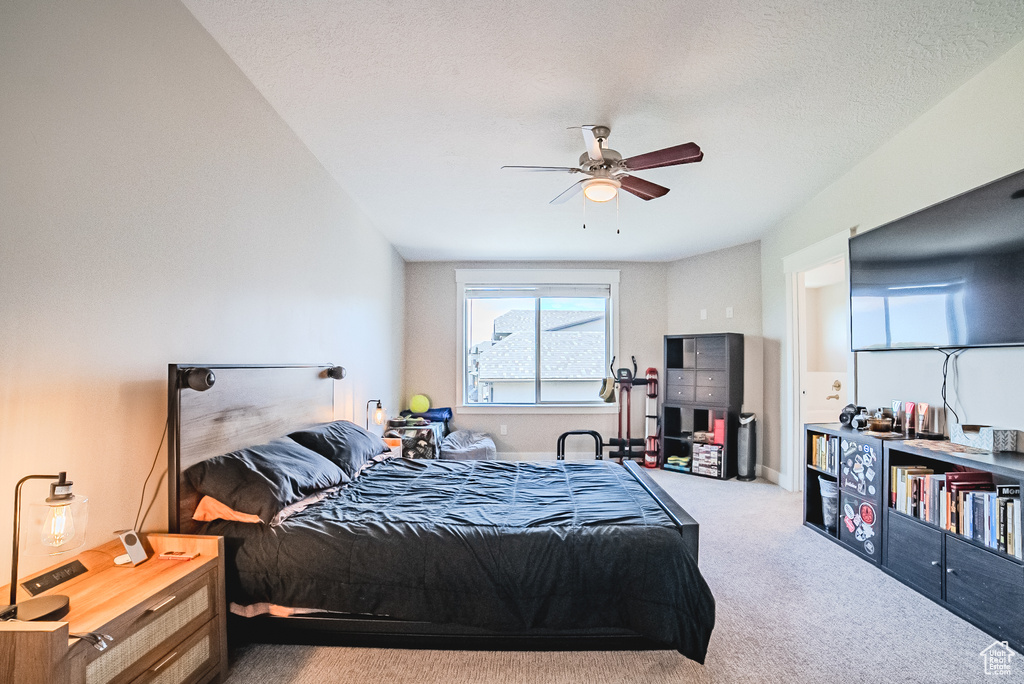 Carpeted bedroom featuring a ceiling fan