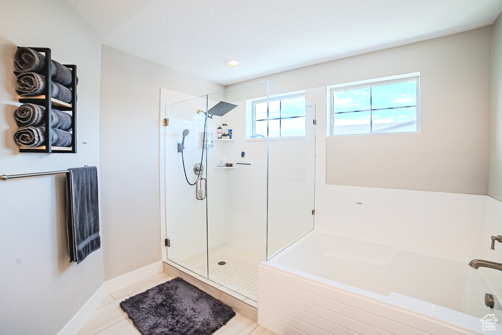 Bathroom featuring a bath, a shower stall, and recessed lighting