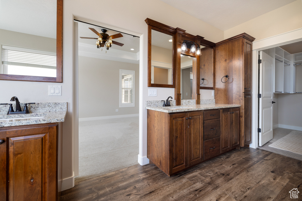 Bathroom with vanity, a ceiling fan, wood finished floors, and healthy amount of natural light