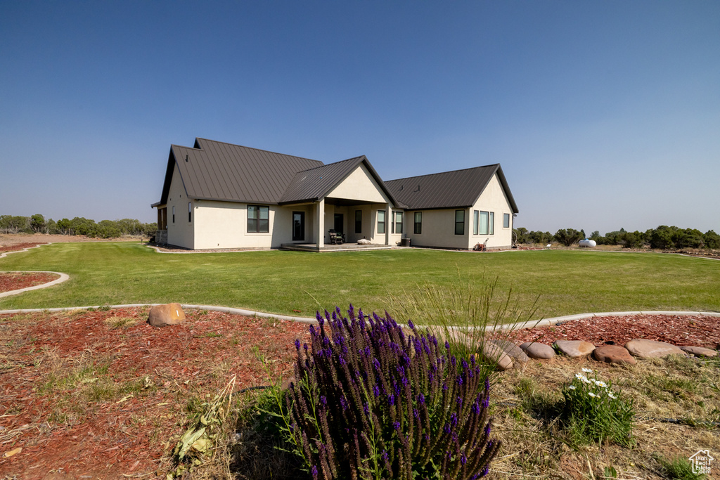 Rear view of house with a yard and a metal roof