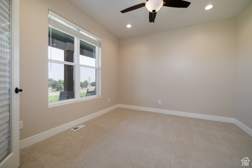 Spare room featuring light carpet, ceiling fan, and recessed lighting