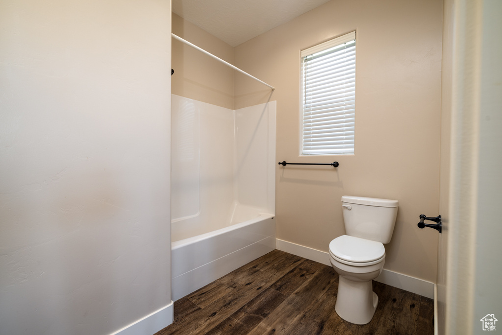 Full bath with wood finished floors and shower / bath combination