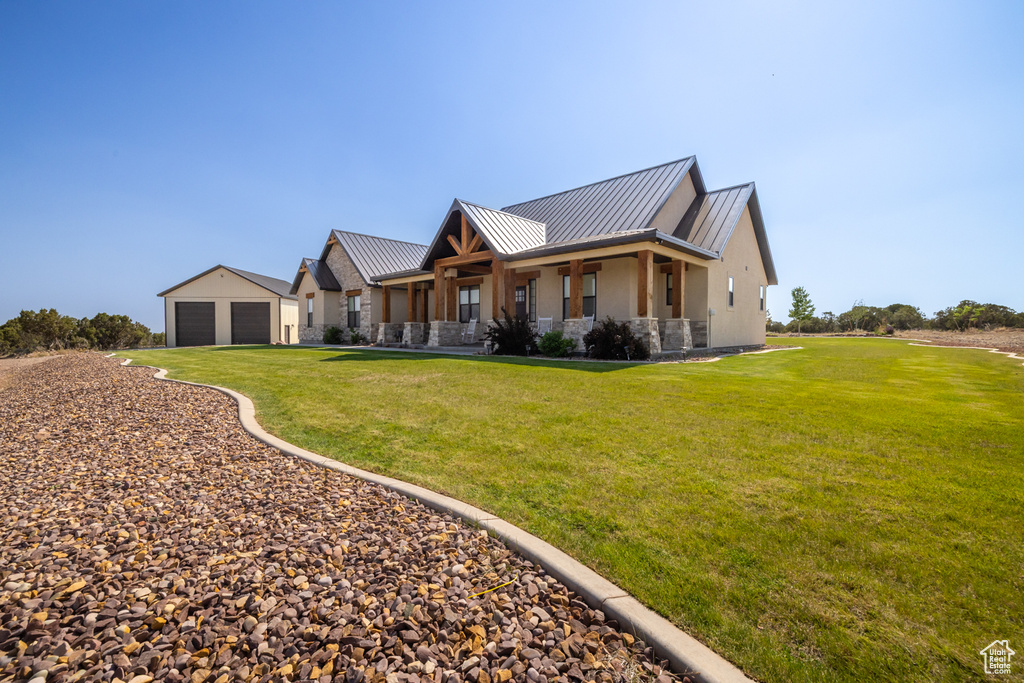 Modern inspired farmhouse featuring a standing seam roof, stone siding, stucco siding, a garage, and a metal roof