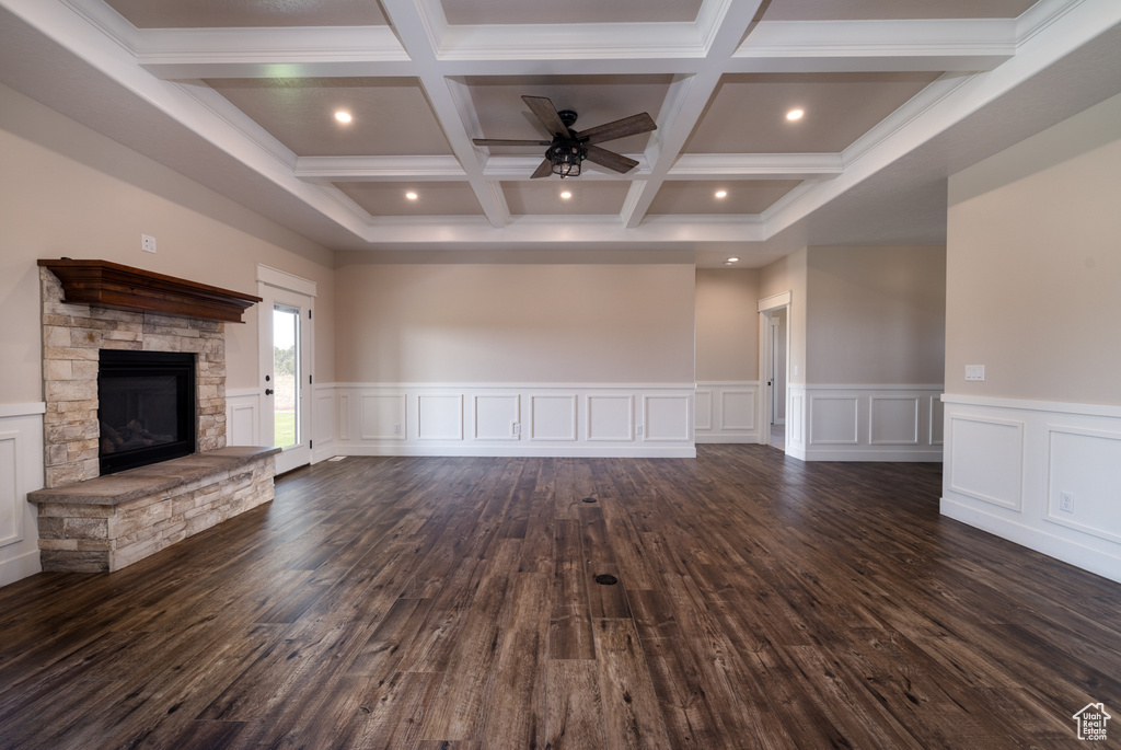 Unfurnished living room with beamed ceiling, ceiling fan, dark wood-style flooring, a fireplace, and coffered ceiling