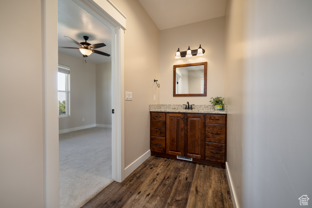 Bathroom with vanity, a ceiling fan, and wood finished floors