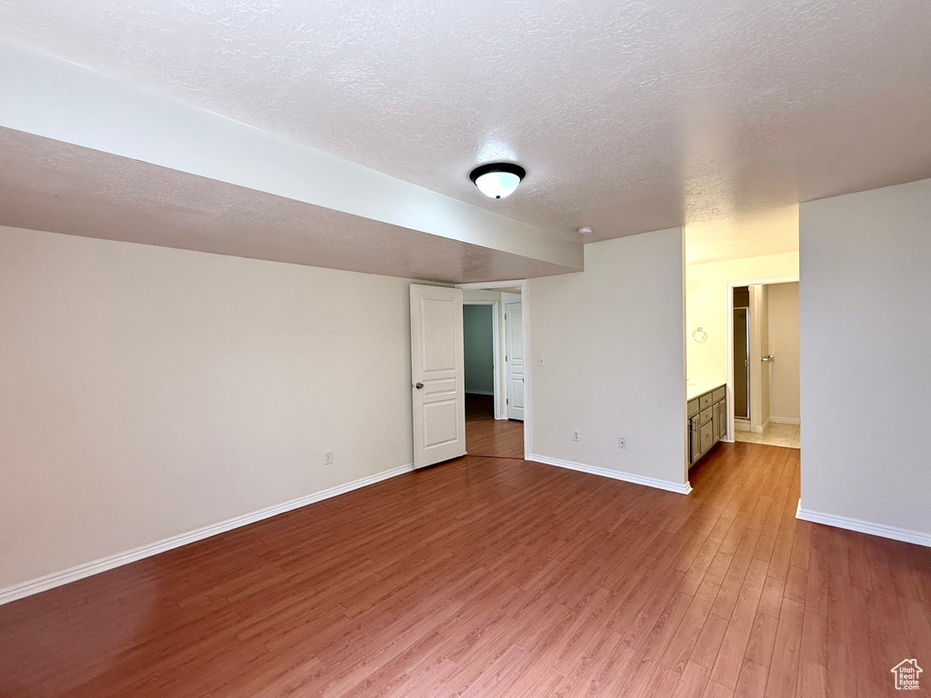 Empty room featuring wood finished floors and a textured ceiling