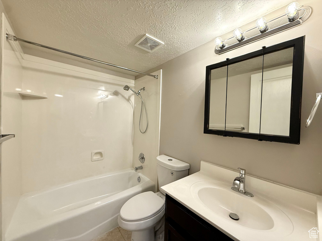 Full bath featuring vanity, bathing tub / shower combination, and a textured ceiling