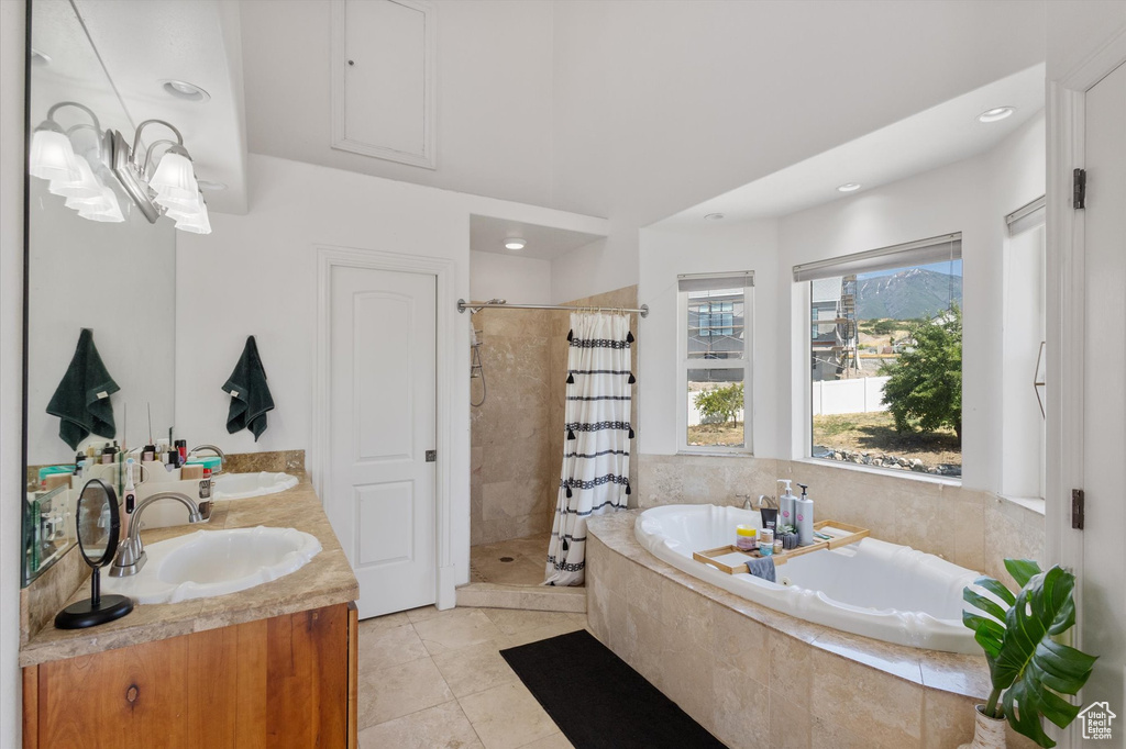 Bathroom with a stall shower, a garden tub, double vanity, tile patterned flooring, and recessed lighting