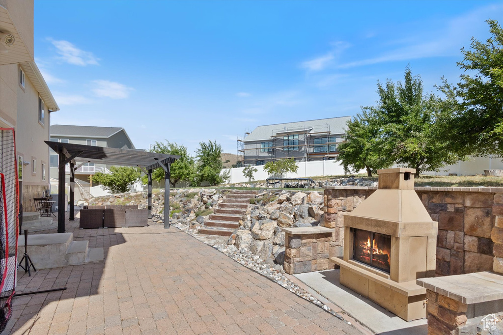 View of patio with a pergola and an outdoor living space with a fireplace
