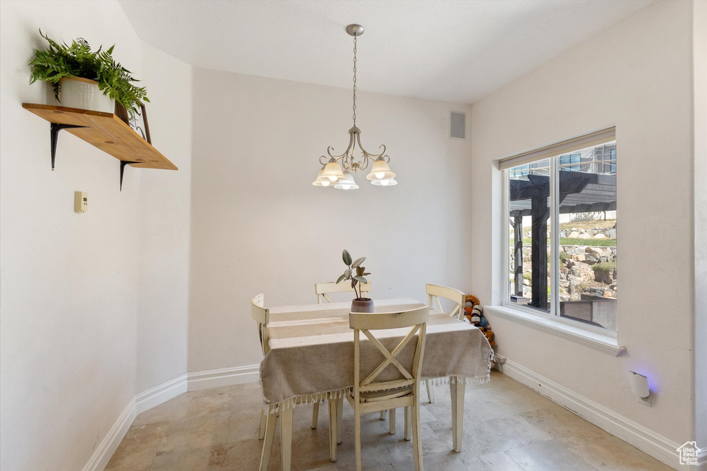Dining space with a chandelier and baseboards