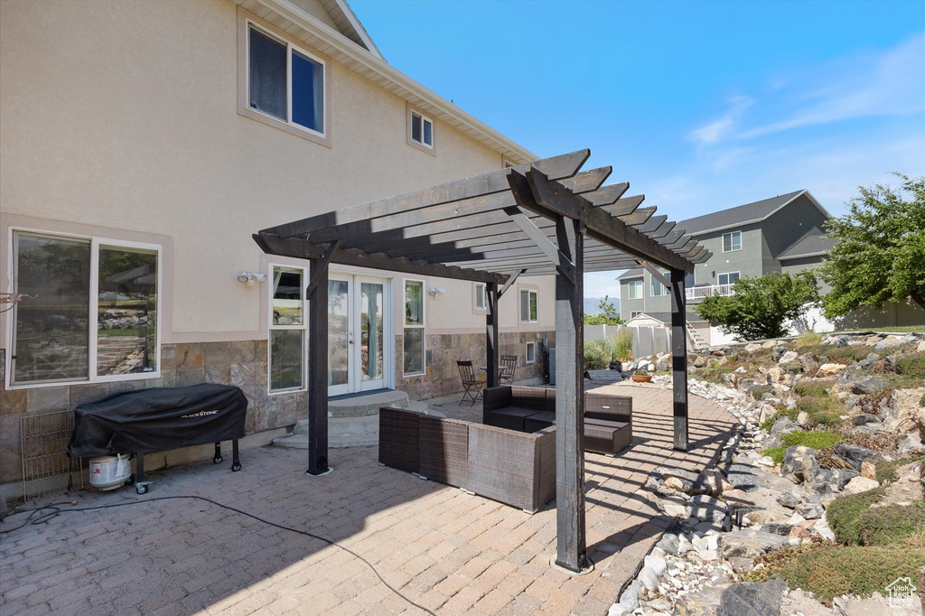 View of patio featuring french doors, area for grilling, a pergola, and outdoor lounge area