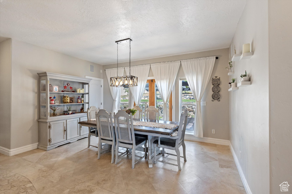 Dining space with a chandelier and a textured ceiling