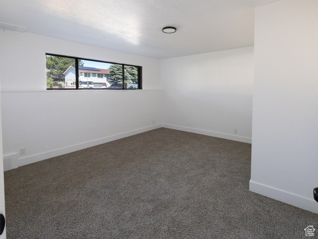 Carpeted empty room featuring baseboards