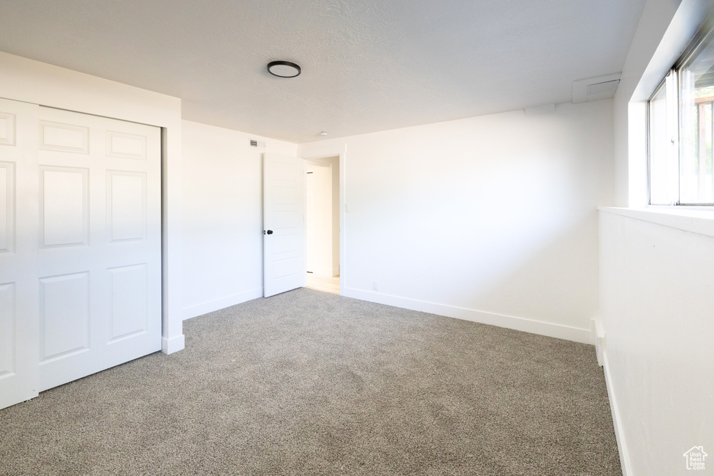 Unfurnished bedroom with carpet and a closet