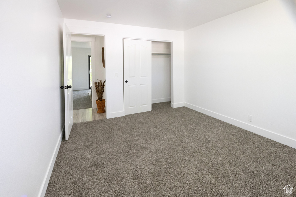 Unfurnished bedroom featuring carpet and a closet