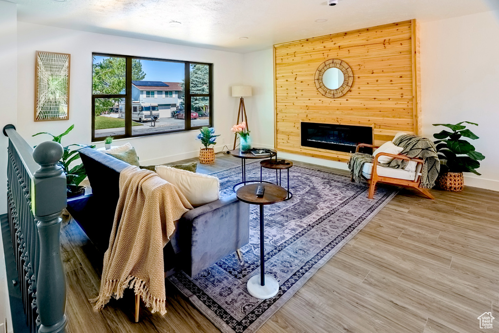 Living room with wood finished floors and a glass covered fireplace