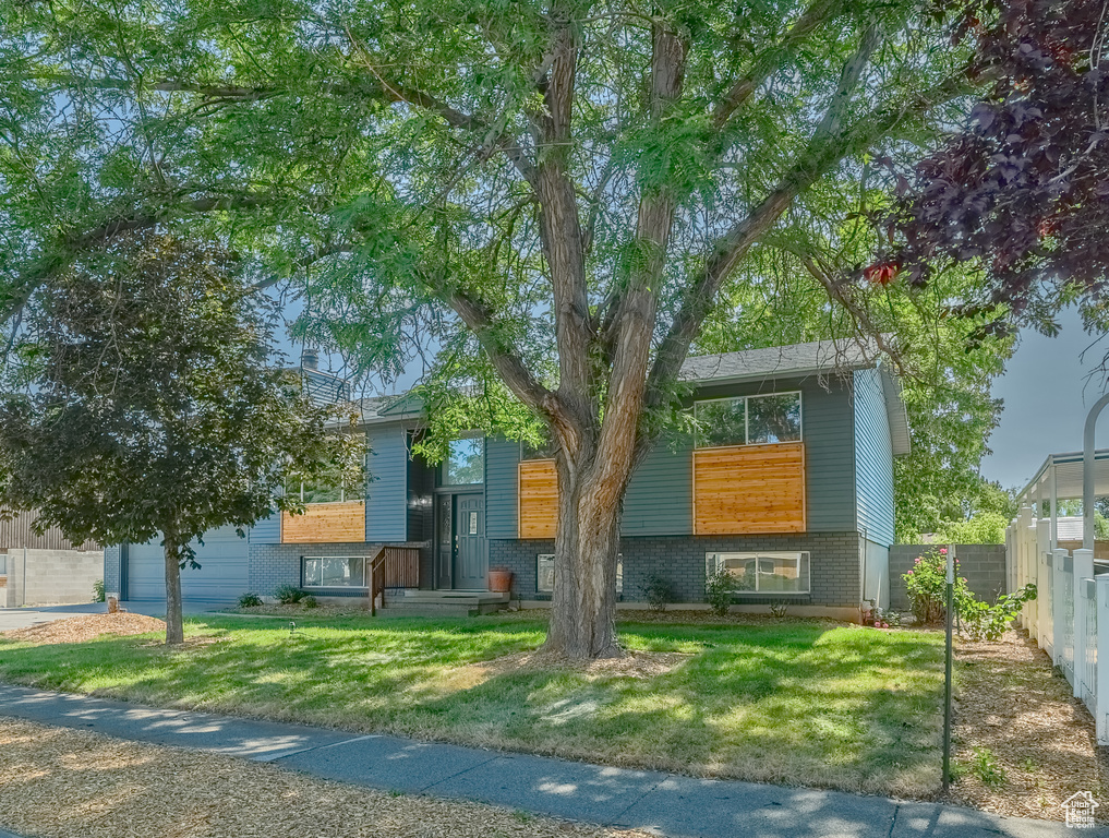 View of front facade featuring brick siding and a garage