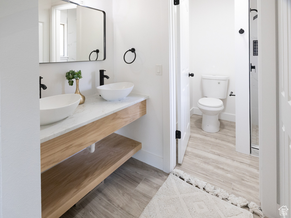 Full bathroom featuring double vanity and wood finished floors