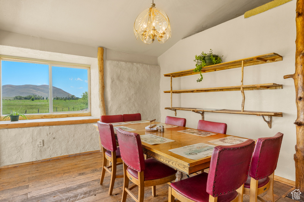 Dining space with vaulted ceiling, hardwood / wood-style flooring, a chandelier, and a mountain view