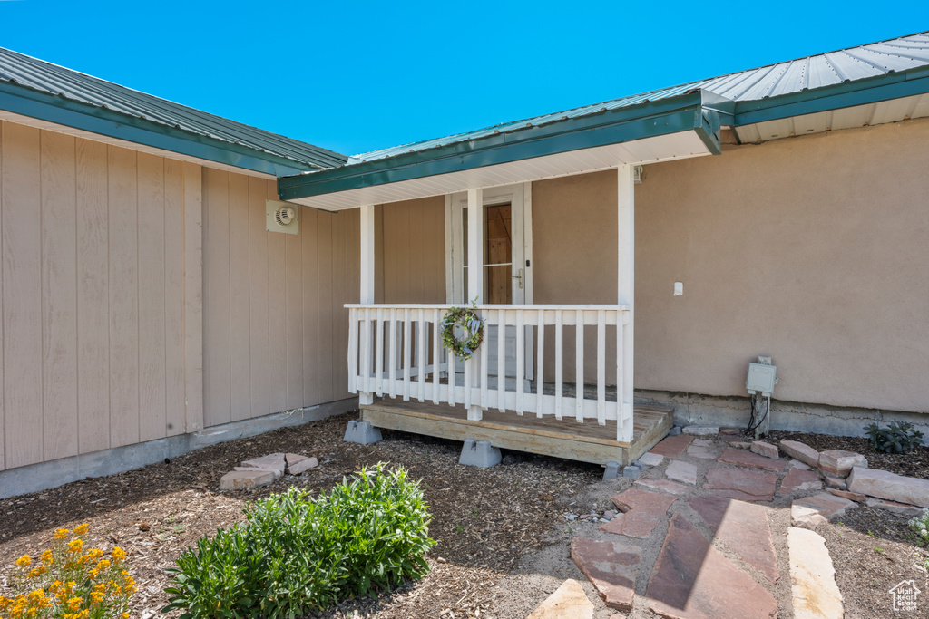 Property entrance featuring covered porch and a metal roof