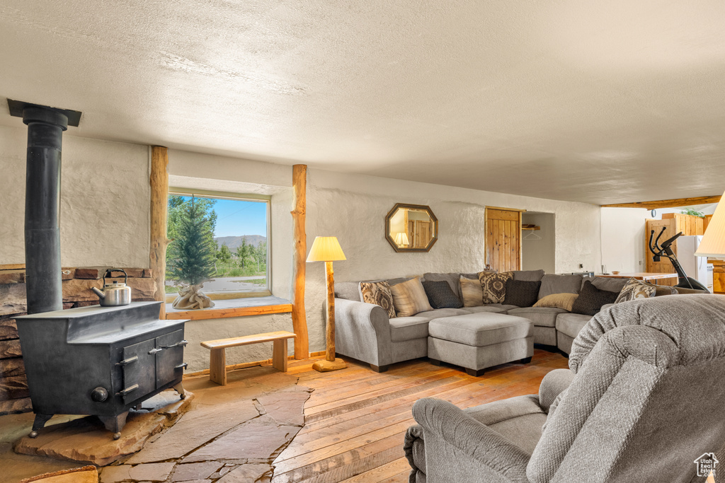 Living area featuring a wood stove, hardwood / wood-style floors, and a textured ceiling