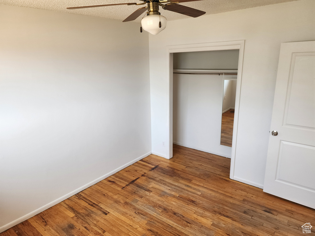 Unfurnished bedroom with wood finished floors, a closet, and ceiling fan