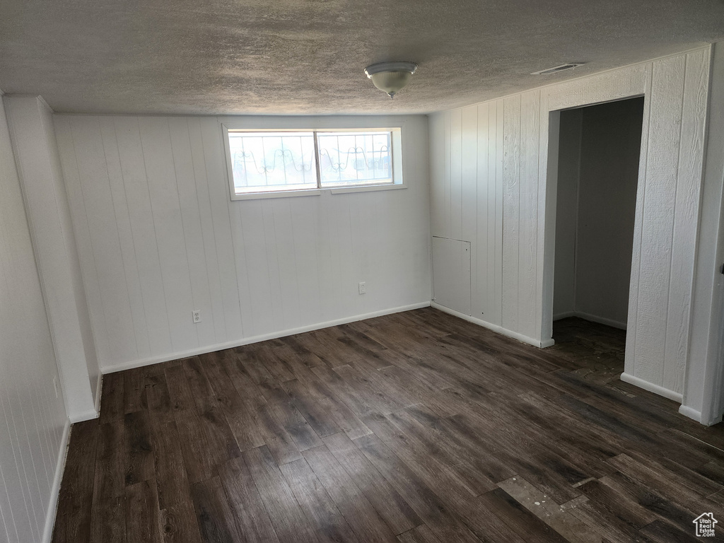 Spare room with dark wood-style floors and a textured ceiling