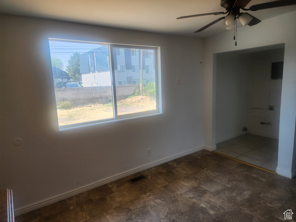 Unfurnished room featuring plenty of natural light and ceiling fan