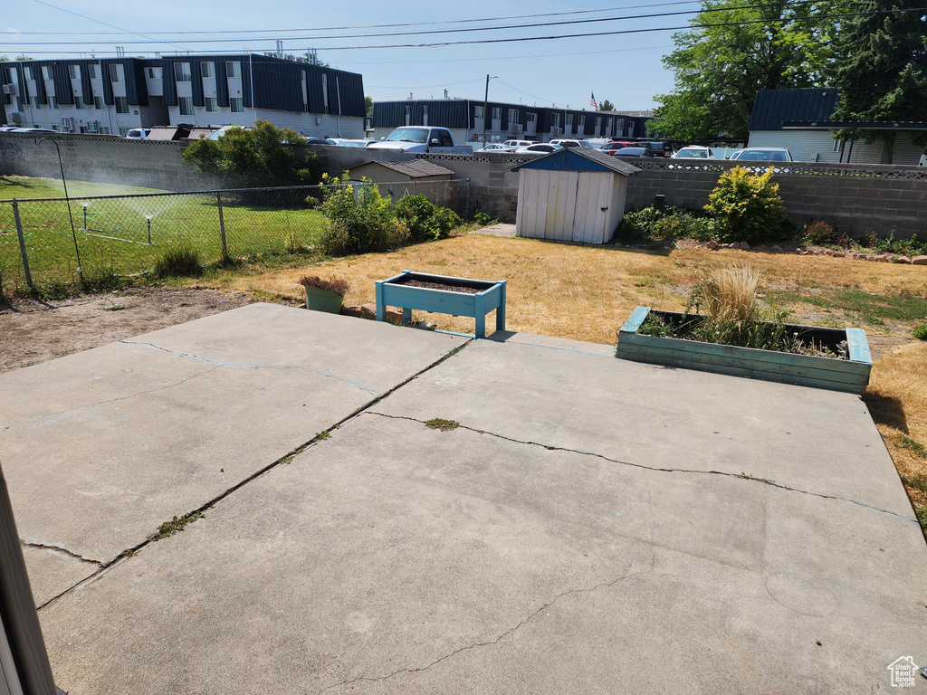 Fenced backyard with a shed and a patio
