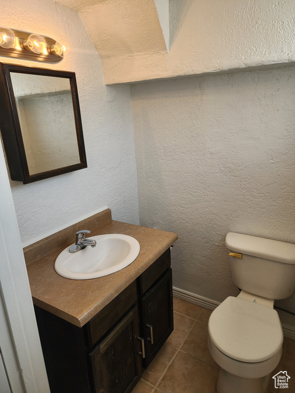 Bathroom with vanity, a textured wall, and tile patterned floors