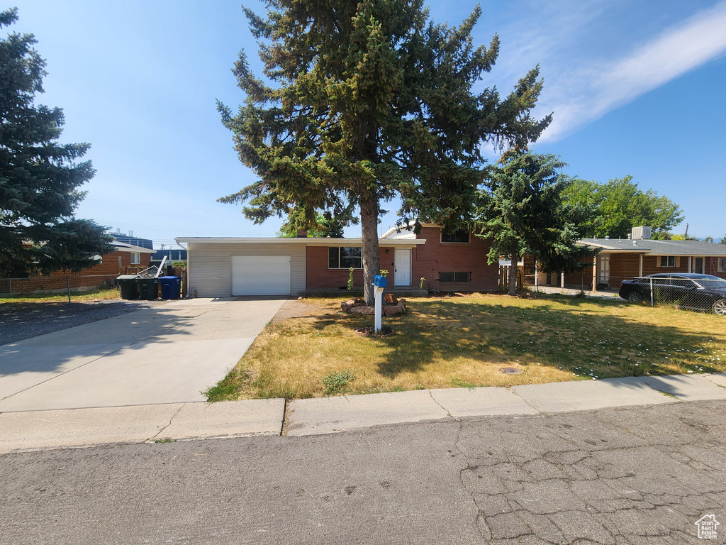 Tri-level home featuring driveway, a front lawn, and a garage