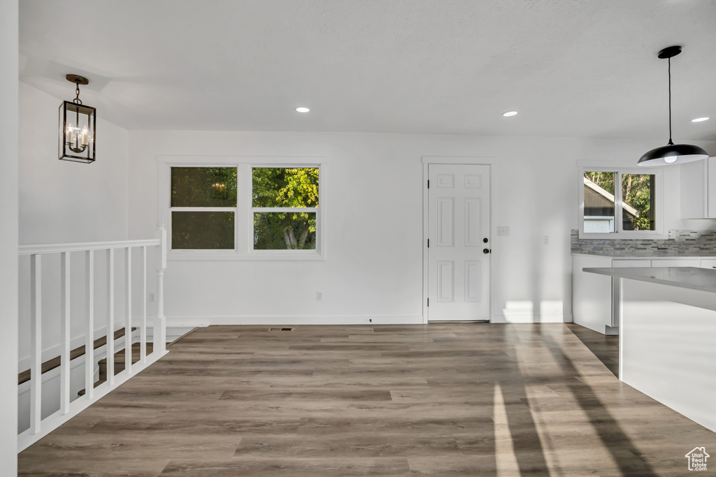Unfurnished dining area with recessed lighting, wood finished floors, and a chandelier