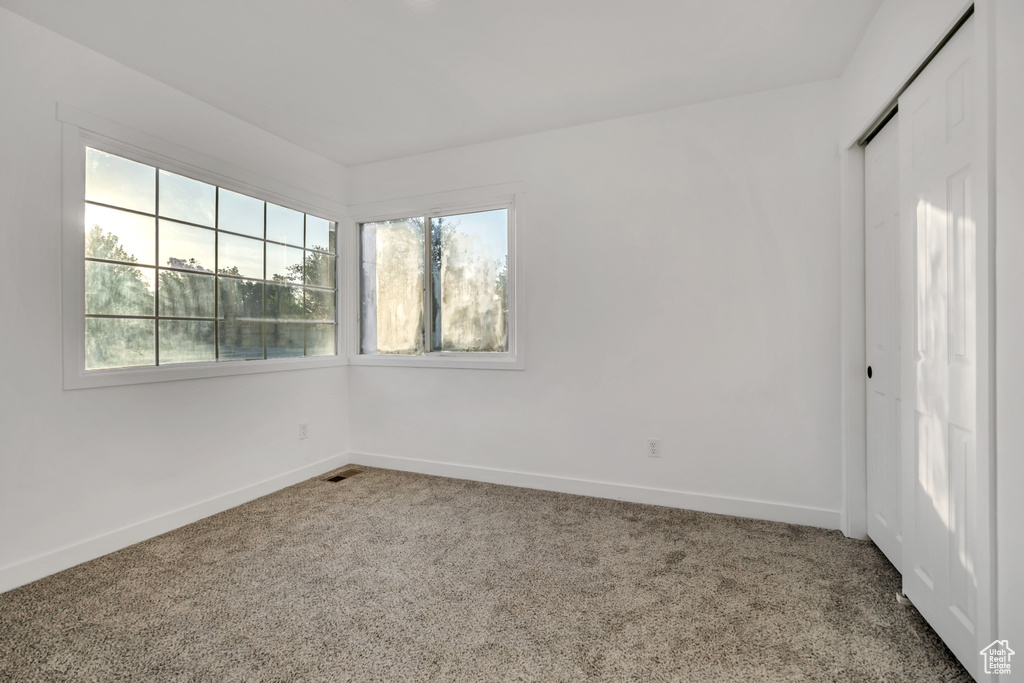 Carpeted empty room featuring baseboards