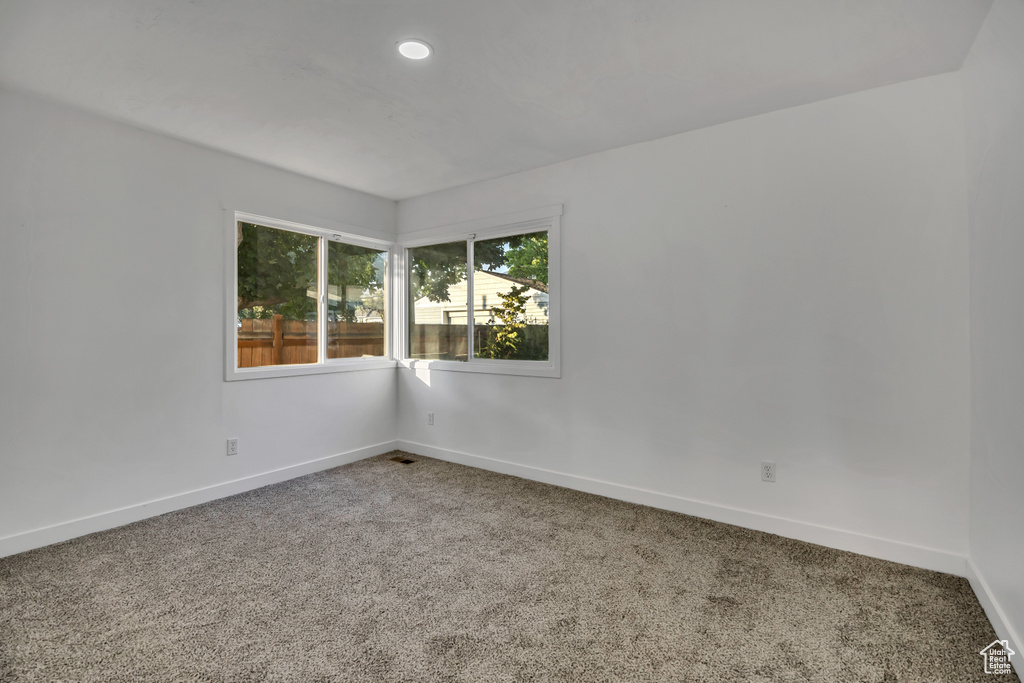 Carpeted spare room featuring baseboards and recessed lighting