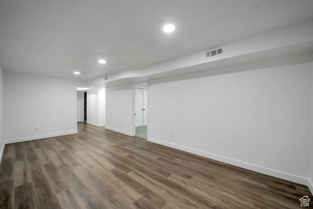 Empty room with recessed lighting and dark wood-style flooring