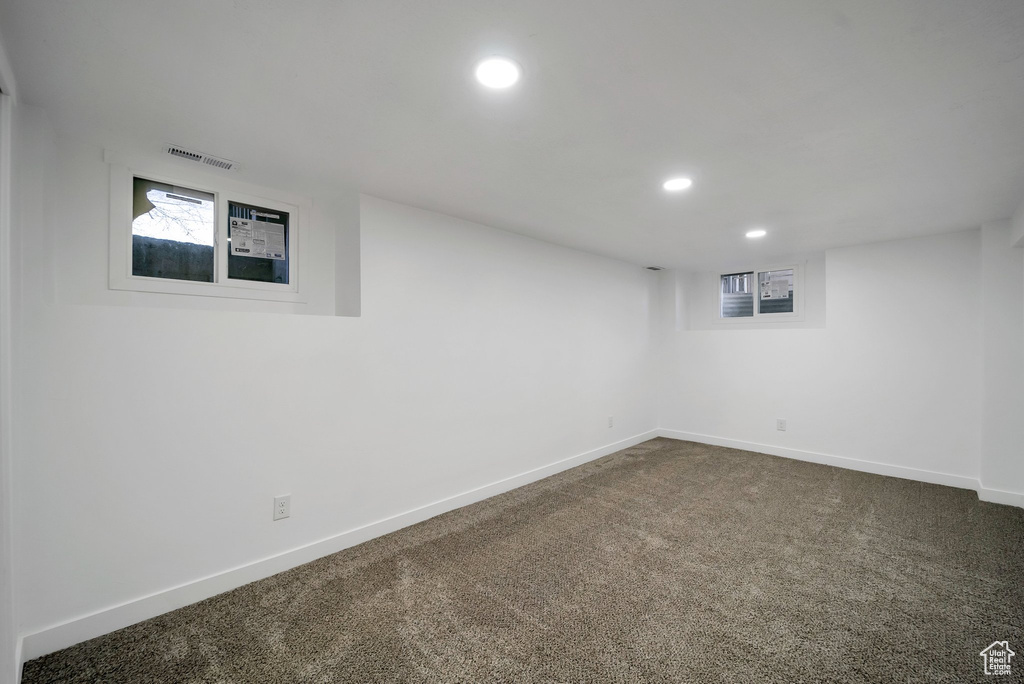 Basement with recessed lighting and dark colored carpet