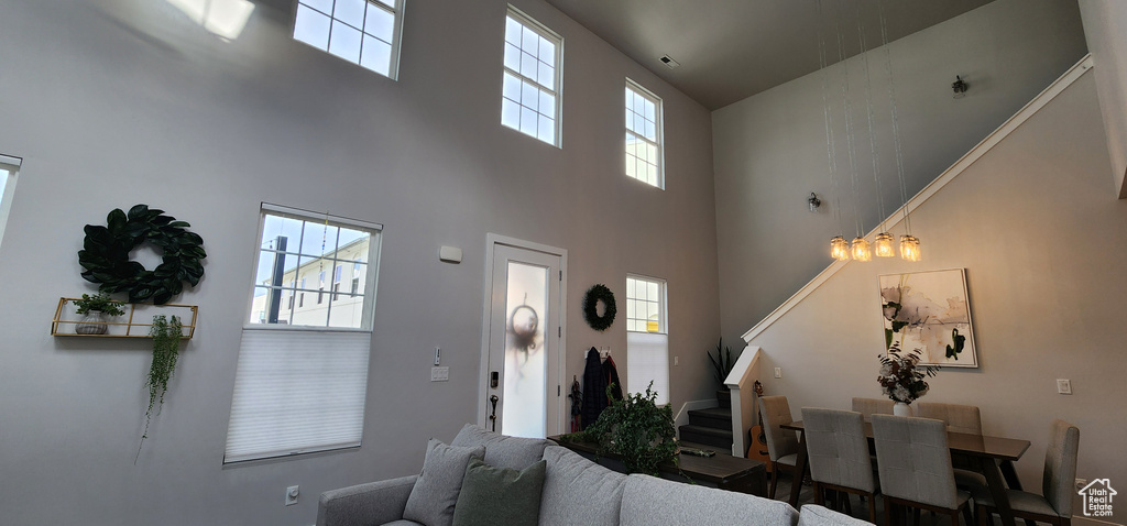Living area with a high ceiling, stairs, and healthy amount of natural light