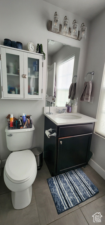 Half bath featuring vanity, tile patterned flooring, and plenty of natural light