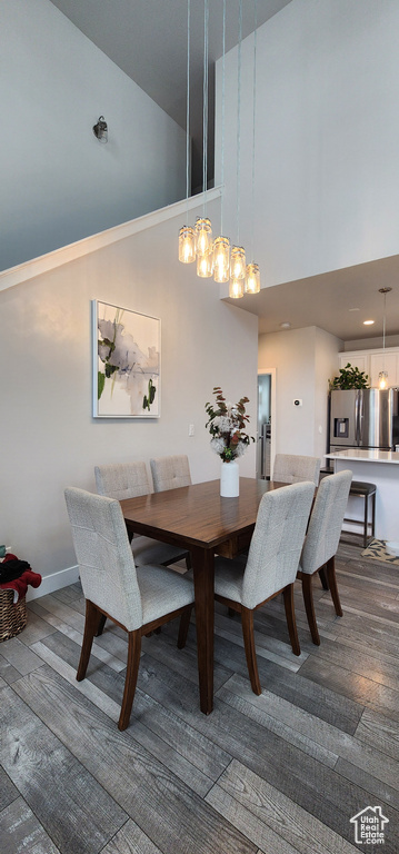 Dining area featuring high vaulted ceiling and dark wood finished floors