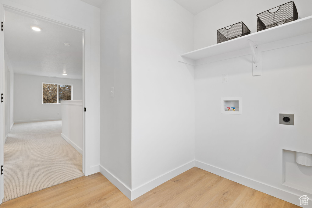 Laundry area featuring hookup for an electric dryer, hookup for a washing machine, and wood finished floors