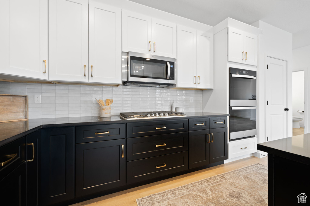 Kitchen featuring stainless steel appliances, white cabinetry, and light wood finished floors