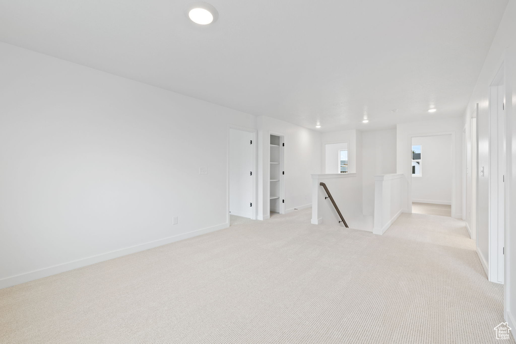 Empty room with baseboards and light colored carpet