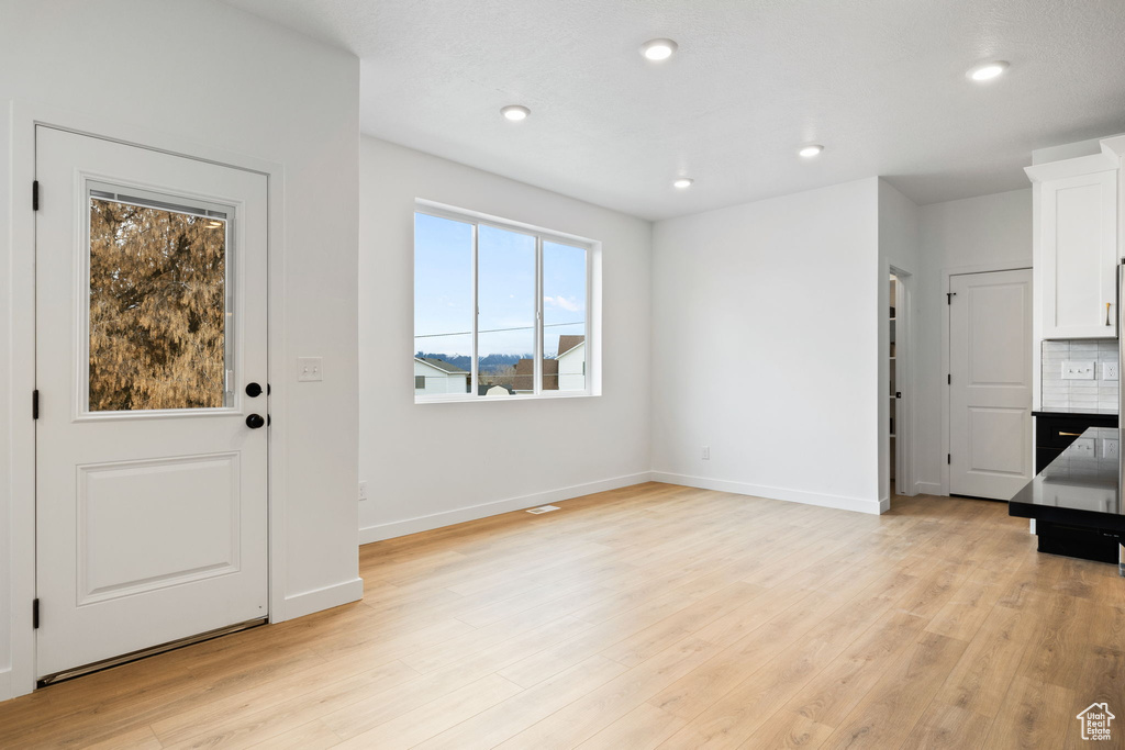 Unfurnished living room featuring light wood-style floors and recessed lighting