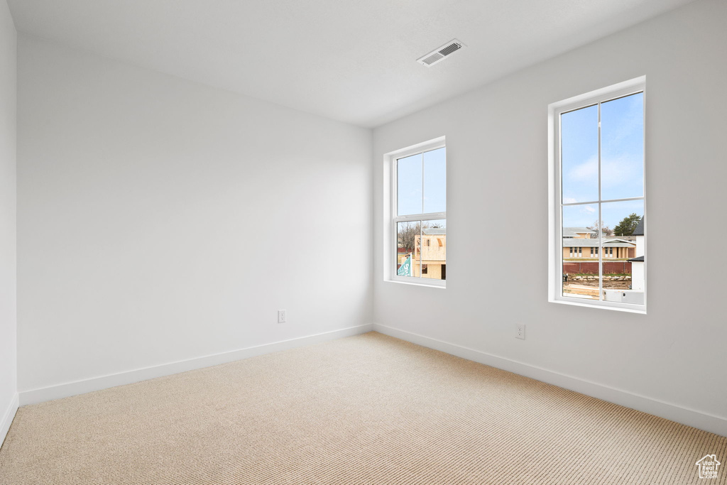 Spare room with light carpet and baseboards