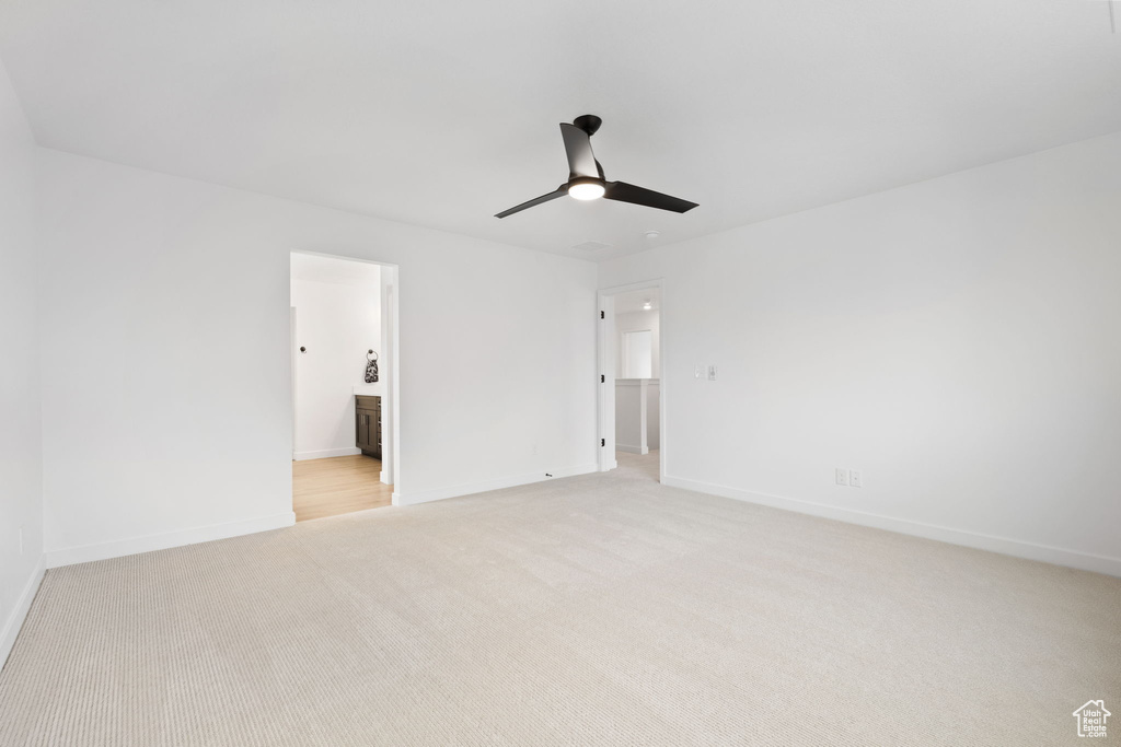 Unfurnished room featuring a ceiling fan and light carpet