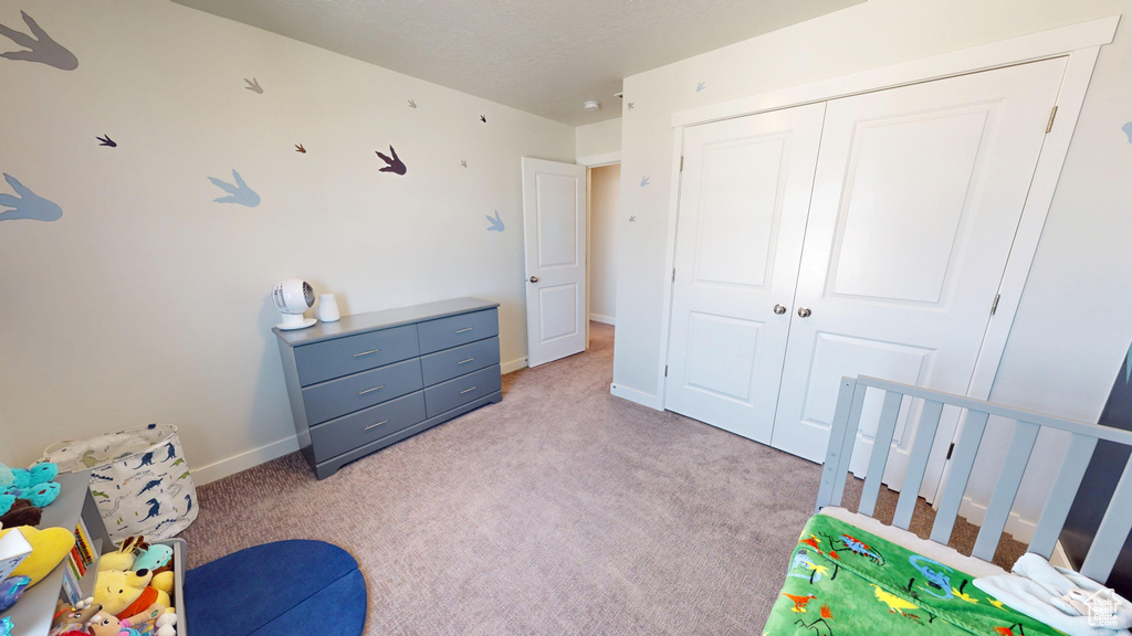 Carpeted bedroom featuring a closet and baseboards