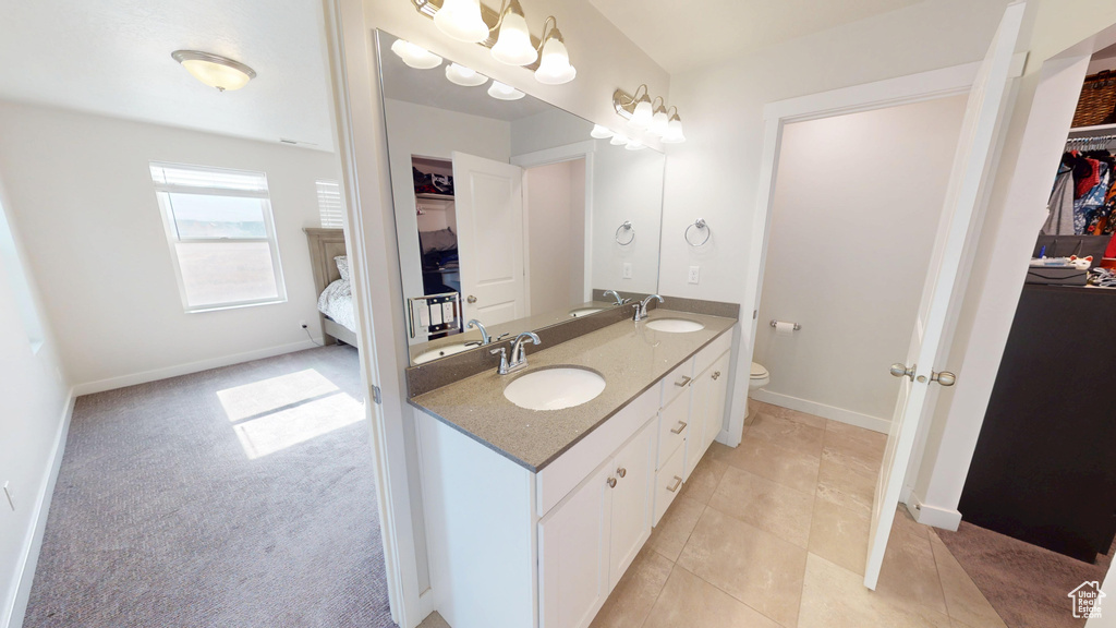 Full bath with double vanity, a spacious closet, and connected bathroom