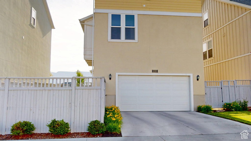 View of front facade featuring stucco siding, an attached garage, and concrete driveway